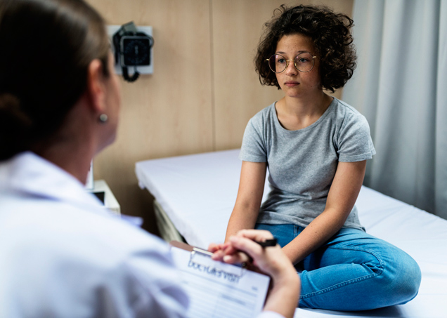 Clinician interviewing a sad looking young girl